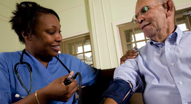 home care nurse taking blood pressure reading